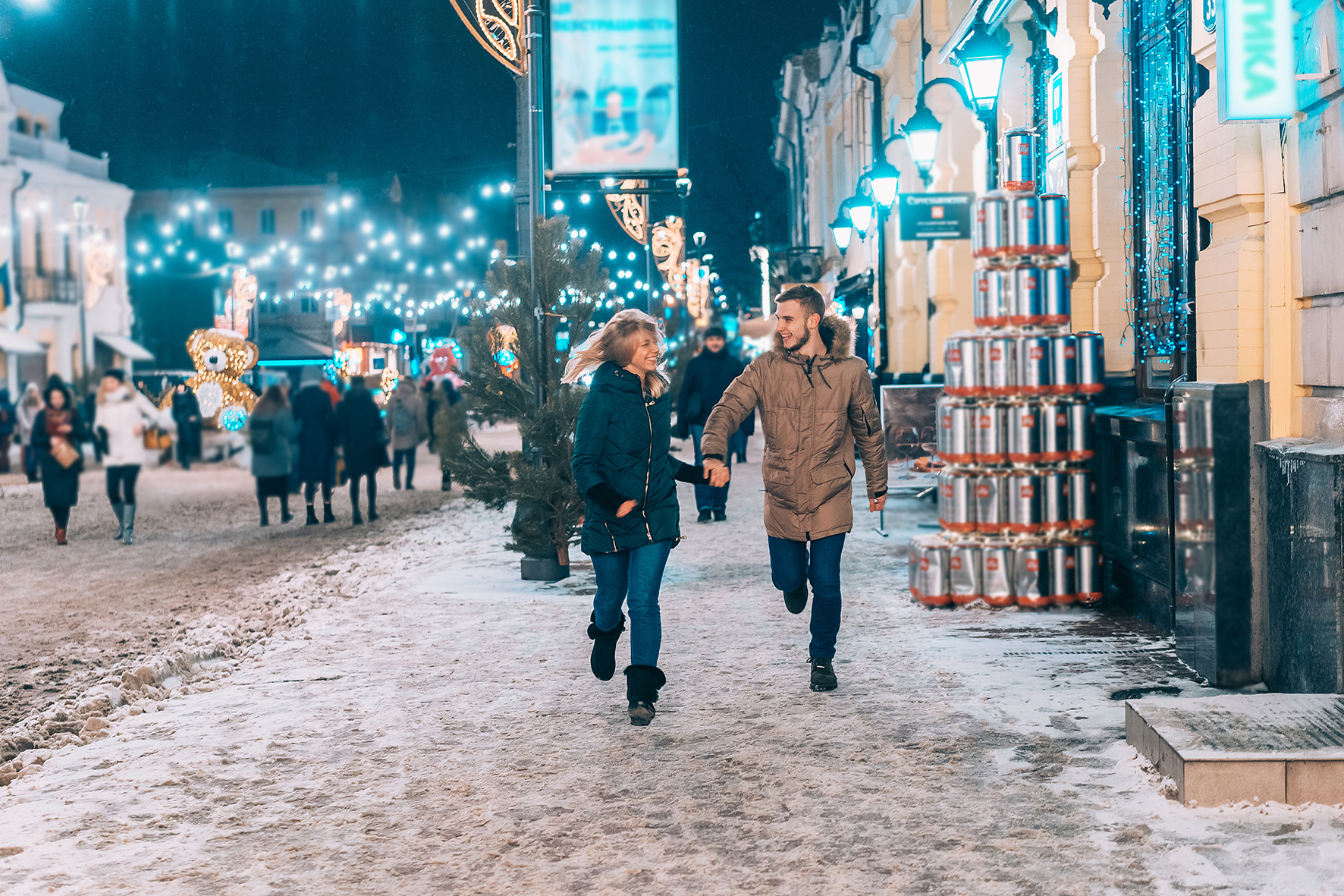 Young adult couple walking on snow covered sidewalk